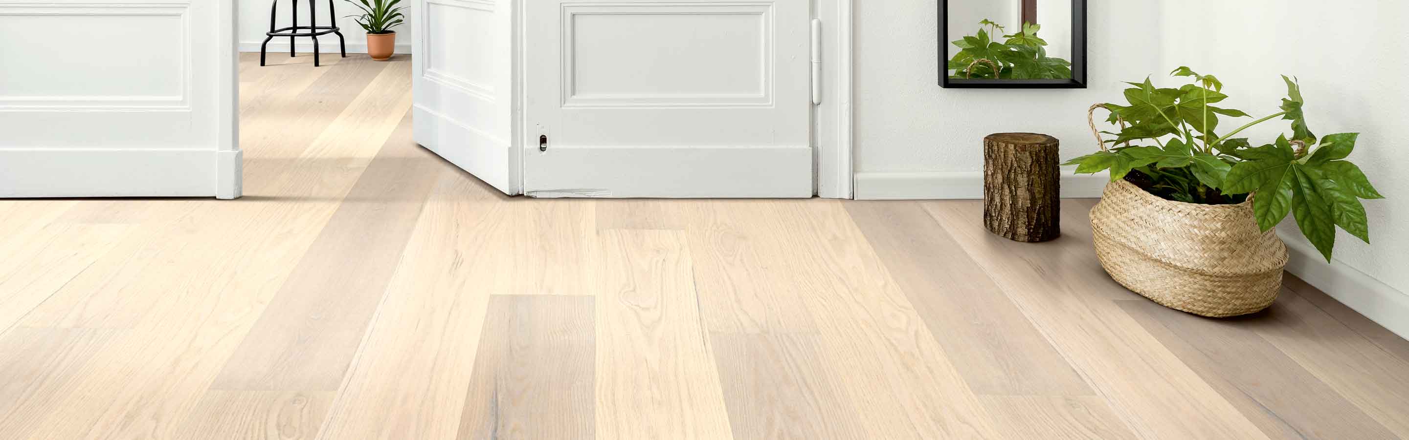 entryway with white oak hardwood floors, full length mirror, and greenery